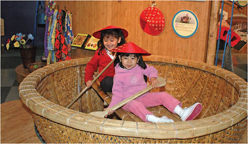 Children explore the Vietnamese round boat, an icon of this culture.