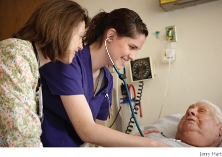 Seasoned nurse and clinical instructor Cathy Meade provides guidance as student Jamie Sharp examines a patient.