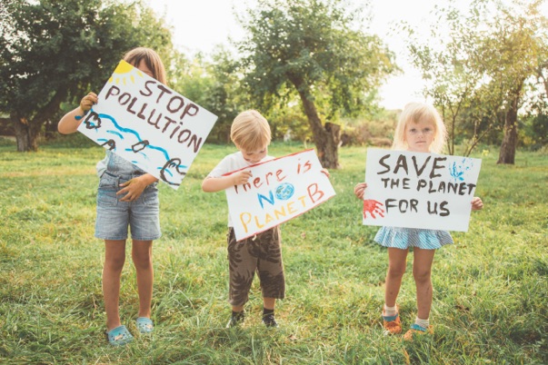 img of kids holding signs about biodiversity